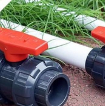 Two FLOTEC double union ball valves installed in-line on a white irrigation pipe